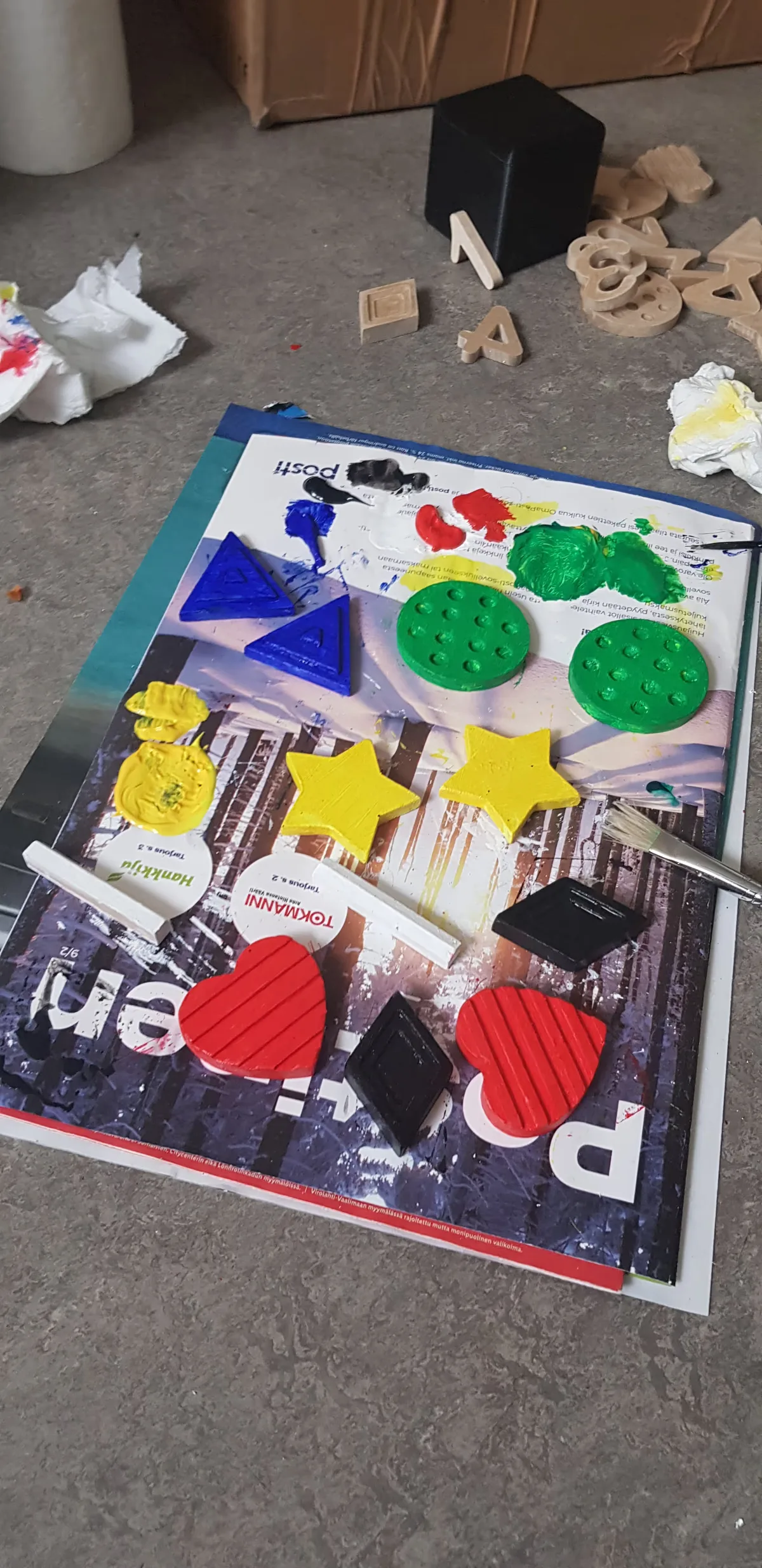 A photo of the labels of the board being colored with a paintbrush