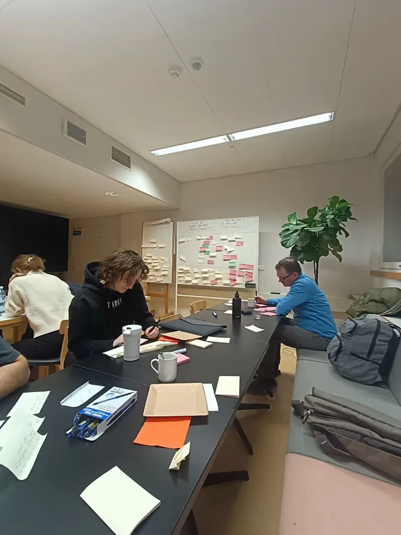 A full view of the whiteboards and everybody on the team working with the CEO to map out the core brief questions